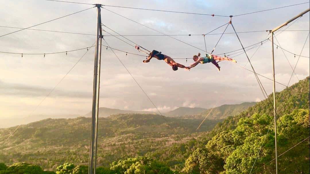 Student mid-swing on the flying trapeze at Airborne Arts Costa Rica