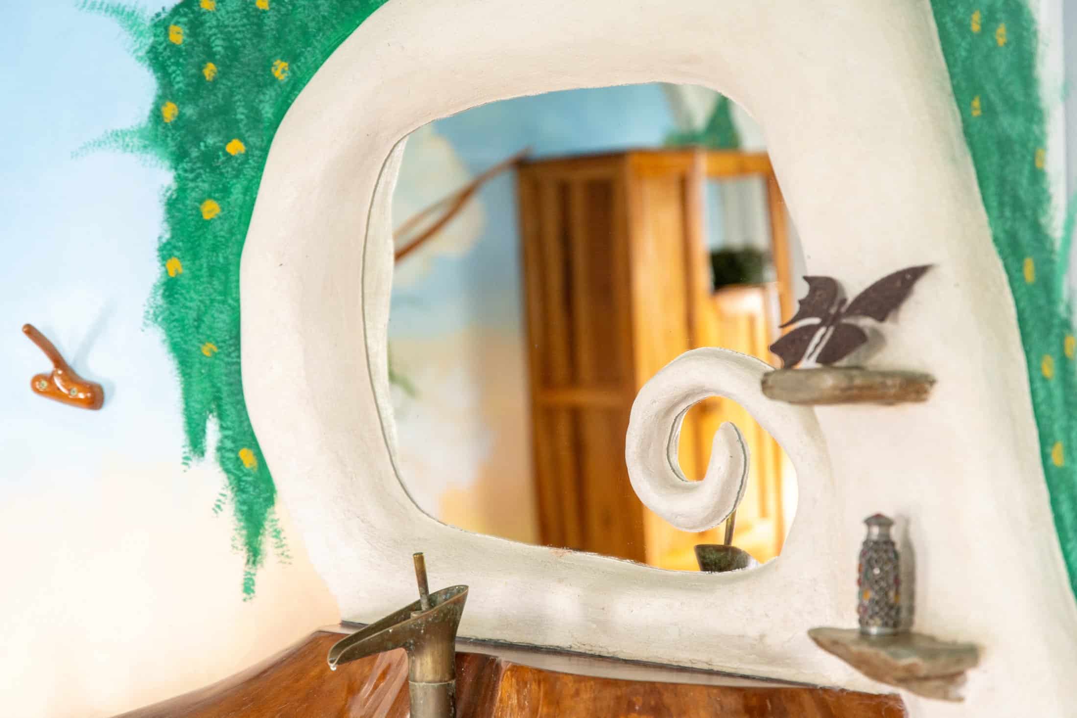 Sculpted plaster mirror frame and natural-wood vanity inside the Master Suite