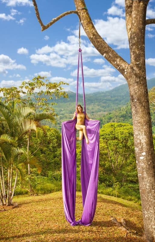 Aerialist performing on silks in the Temple of Light open-air pavilion at Airborne Arts