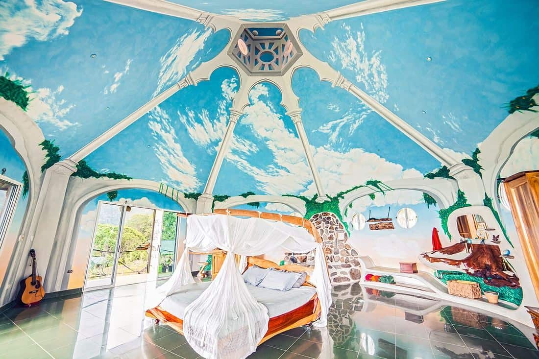 The Master Suite at Airborne Arts featuring a hand-crafted sleigh bed beneath a thirty-foot painted ceiling with sky murals