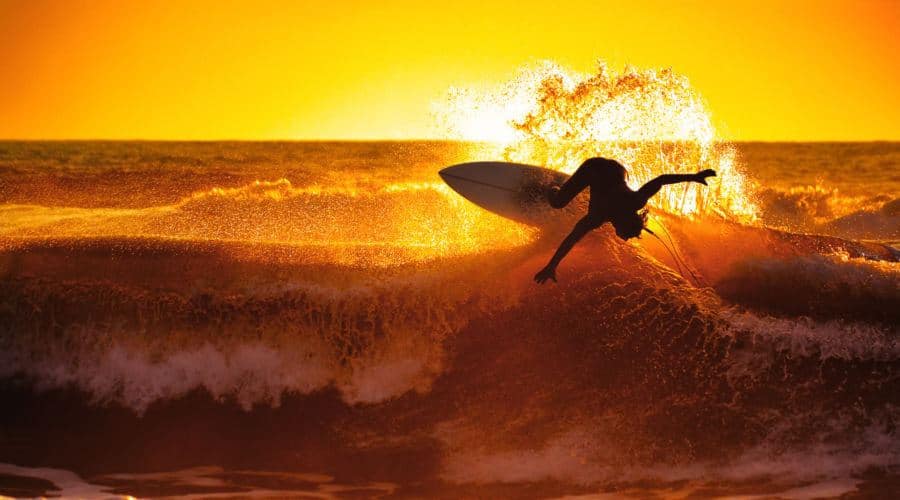 Surfer riding a wave at Dominical beach, one of Costa Rica's best Pacific coast surf spots